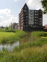 Appartementengebouw op de hoek van Houten Castellum met de Porta Basilica met op de voorgrond het groene carré. Foto: André Botermans.