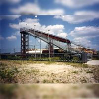 Zicht op de net een half jaar opgeleverde fietsbrug over de Staatslijn H in in de zomer van 2001 bij Houten Castellum. Om het spoor een voorbij razende goederentrein met ketelwagens. Foto: Regionaal Archief Zuid-Utrecht (RAZU), 353.