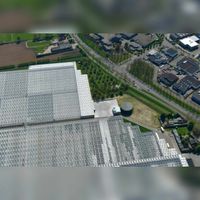 Luchtfoto gezien vanuit het noorden met de Utrechtseweg en het kassencomplex van Jongerius in Oud-Wulven tussen de Utrechtseweg en de Oud Wulfseweg. Foto: Slagboom en Peeters Luchtfotografie B.V..