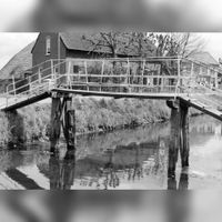 Gezicht op een bruggetje over de Schalkwijksche Wetering te Schalkwijk (gemeente Houten), met op de achtergrond de boerderij Provincialeweg 27 (Geerhoeve) in mei 1967. Bron: HUA, 841065.