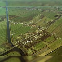 Luchtfoto van Molenbuurt (gemeente Houten), uit het zuiden, met de bebouwing langs de Lange Uitweg en haaks daarop de Waalseweg. Links het Inundatiekanaal en links op de voorgrond een deel van het fort Werk aan de Korte Uitweg. Bron: HUA, 50142.