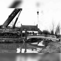 Het plaatsen van een brug over de Houtensewetering in 1985 kort na het gereedkomen van De Staart naar de rijksweg A27. Bron: onbekend.