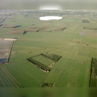 Luchtfoto van de polder Vechter- en Oudwulverbroek (deels gemeente Houten en deels gemeente Bunnik), uit het zuidoosten, vóór de uitbreiding van Houten, met in het midden de Geersloot op 11 januari 1981. De witte vlek op de achtergrond is het op het negatief afgedekte fort Vechten.