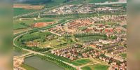 Luchtfoto gezien vanuit het zuiden op de wijk Houten noordwest met het manifestatieterrein in het Imkerspark. Linksonder bedrijfterrein De Veste (voorheen Het Rondeel genaamd). Beeld uit 1996-1997. Bron: Regionaal Archief Zuid-Utrecht (RAZU), 353.