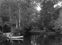 Gezicht op een gezin in een roeiboot op de Kromme Rijn met op de achtergrond een gedeelte van de voorgevel van de hofstede Rhijnauwen (Rhijnauwenselaan 14) te Bunnik in 1920-1930. Bron: Het Utrechts Archief, catalogusnummer: 41111.