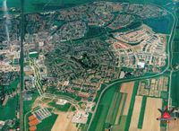 Luchtfoto vanuit het zuiden van het oostelijke deel van de kern Houten, aangeboden ter gelegenheid van het 40-jarig jubileum van de woningbouwvereniging Dr. Schaepman in 1992. Bron: Regionaal Archief Zuid-Utrecht (RAZU), 353, 105242, 116.