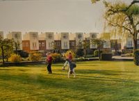 Drie spelende kinderen in de achtertuin van (voormalige) boerderij Loerikerhofstede aan de Binnentuin 55 met op de achtergrond huizen aan de Heidetuin in ca. 2002. Bron: Collectie gemeente Houten.