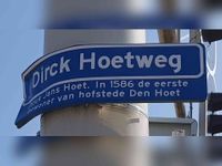 Straatnaambord hangend aan de stoplichtmast met de kruising van de Grauwaartsingel met de Dirck Hoetweg met de beschrijving erop van de betekenis van de straatnaam: 'Dirck Jans Hoet'. In 1586 de eerste bewoner van hofstede Den Hoet. Foto in maart 2021, Sander van Scherpenzeel.