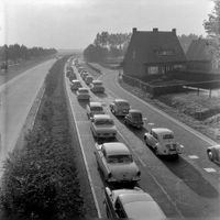 Afbeelding van een file op de Rijksweg 12 bij Utrecht, gezien vanaf het viaduct in de Houtenseweg bij De Koppel in het voorjaar of de zomer van 1962. Bron: Het Utrechts Archief, catalogusnummer: 125634.