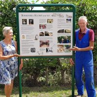 Echtpaar Marja en Henk Klever (eigenaren boerderij) bij hun nieuwe informatiebord over boerderij De Klomp op zondag 21 juni 2020. Foto: Sander van Scherpenzeel.