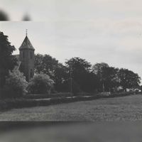 Links de toren van de rooms-katholieke kerk met op de voorgrond de Beusichemseweg in 1977. Bron: Regionaal Archief Zuid-Utrecht (RAZU), 353.