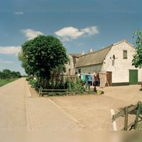 Gezicht op de zij- en achtergevel van de boerderij Hoogdijk 2 te Houten, uit het zuidwesten; op de achtergrond de kruising met de Beusichemseweg op maandag 1 juli 1996. Bron: Het Utrechts Archief, catalogusnummer: 123679.