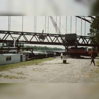 Een binnenvaartschip dat wordt overgeladen van zijn goederen op een vrachtwagen op de Tripkade op 30 juni 1989 op de achtergrond de Schalkwijkse Spoorbrug. Bron: Regionaal Archief Zuid-Utrecht (RAZU), 353.