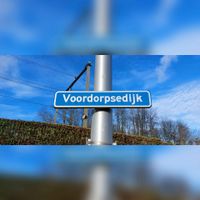 Zicht op het straatnaambord 'Voordorpsedijk' op de plek tussen de spoorwegovergang en ondergang van de spoorlijn Utrecht- Amersfoort, hoofdbaan en sprinterbaan. Gezien in februari 2022. Foto: Sander van Scherpenzeel.