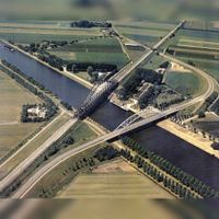 Het Amsterdam-Rijnkanaal met links de Schalkwijkse Spoorbrug in de Staatslijn H (Utrecht-'s-Hertogenbosch-Boxtel) met de weg met bocht voor een gedeelte de toenmalige Schalkwijkseweg over de Schalkwijksebrug. In de periode 1990-1996. Bron: Regionaal Archief Zuid-Utrecht (RAZU), 353.