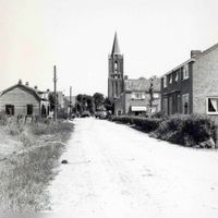 De weg gezien richting het dorp met de woningen aan weerskanten en op de achtergrond de toren van de Nederlands Hervormde Kerk in ca. 1960. Bron: Regionaal Archief Zuid-Utrecht, identificatienummer: doos05 (040909).