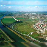 Luchtfoto gezien vanuit het het zuiden met de zuidwestelijke Rondweg met de nog te bouwen buurten De Polders, De Waters en een gedeelte van De Houten op donderdag 21 oktober 2004. Collectie: gemeente Houten.