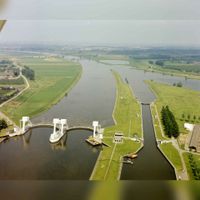 Luchtfoto van de stuw en de schutsluis in de Lek te Hagestein (gemeente Vianen) uit het zuidoosten op dinsdag 23 juni 1983. Bron: Het Utrechts Archief, catalogusnummer: 50725.