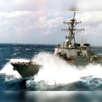 Storm op zee met het overslaande buiswater of de USS Mitscher. Bron: Wikipedia.