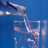 Een glas wat wordt gevuld met mineraalwater (platwater). Bron: Pixabay.