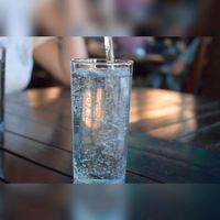Een glas wat wordt gevuld gazeuse water. Bron: Pixabay.
