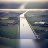 Luchtfoto vanuit het westen met het Amsterdam-Rijnkanaal in zuidoostelijke richting gezien in de periode rond 1990. Bruggen over het kanaal de Schalkwijkse Spoorbrug en Schalkwijksebrug. Foto: Jos Schalkwijk.