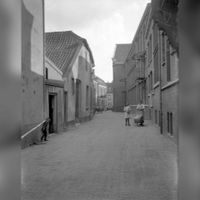 Gezicht in de Lange Rietsteeg te Utrecht, uit het noorden in 1925. Naar een foto van J.W. Deetman. De straatnaam Lange Rietsteeg is in 1950 gewijzigd in Keizerstraat. Bron: Het Utrechts Archief, catalogusnummer: 60058.