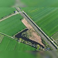 Luchtfoto van de Honswijkerwetering ter hoogte van de spooroverweg met de Achterdijk en Pothuizerweg in 2019. Foto: Slagboom en Peeters Luchtfotografie B.V..
