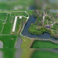 Luchtfoto gezien vanuit het noorden, met zicht op de Singelweg, als onderdeel van de slotgracht van Fort Honswijk. Linksboven de Gedekte Gemeenschapsweg. Foto: Slagboom en Peeters Luchtfotografie B.V..