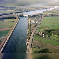 Luchtfoto van de splitsing van het Amsterdam-Rijnkanaal (voorgrond) en het Lekkanaal te Nieuwegein, uit het zuidoosten, tijdens de werkzaamheden ten behoeve van de omlegging van het Amsterdam-Rijnkanaal langs de Plofsluis. Rechts op de achtergrond de Nieuwegeinsebrug op 11 januari 1981. Bron: HUA, catalogusnummer: 50592.