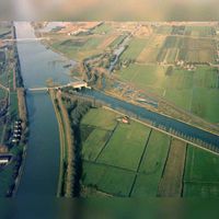 Luchtfoto van de splitsing van het Amsterdam-Rijnkanaal en het Lekkanaal (links) te Nieuwegein, uit het zuiden, tijdens de werkzaamheden ten behoeve van de omlegging van het Amsterdam-Rijnkanaal langs de Plofsluis. Links op de achtergrond de Nieuwegeinsebrug op 11 januari 1981. Bron: HUA, catalogusnummer: 50601.